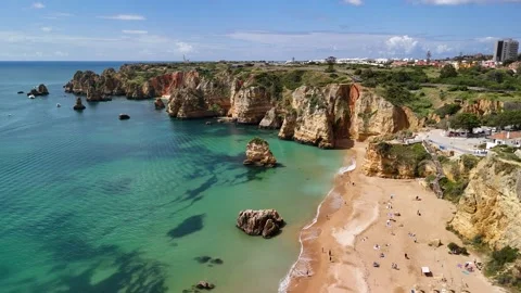 Orange sandy beach with clear turquoise and colourful cliffs in Lagos, Algarve Vídeo Stock 310563645