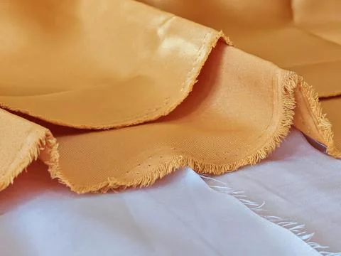 Orange satin fabric texture with soft folds and natural lighting background Stock Photos
