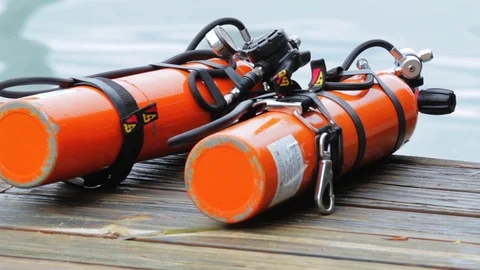 Orange scuba diving tanks sitting on tropical dock before dive Stock Footage 87366318