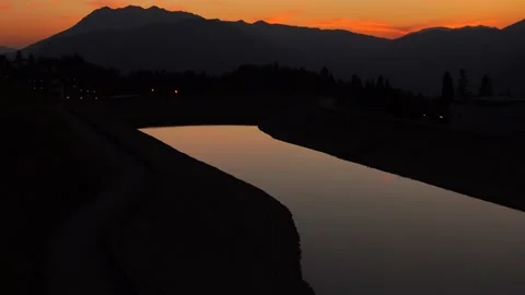 Orange setting sun, a large body of water in a tourist village in the mountains Stock Footage 158276864