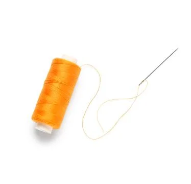 Orange sewing thread spool with needle isolated on white background, closeup Stock Photos
