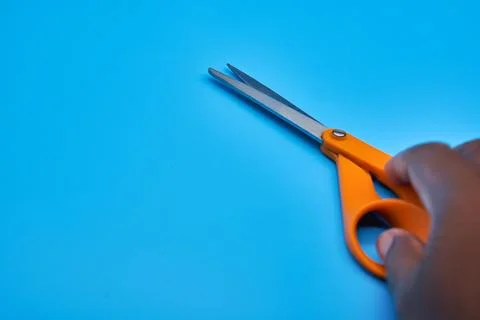 Orange shear scissors on a light blue background cutting shears Stock Photos