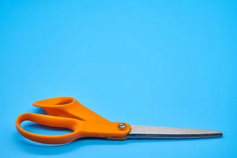 Orange shear scissors on a light blue background cutting shears Stock Photos