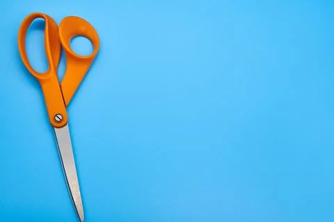 Orange shear scissors on a light blue background cutting shears Stock Photos