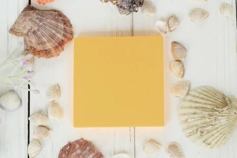 Orange sheet of paper and seashells on a wooden background.Travel background Stock Photos