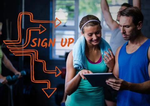 Orange sign up text next to man and woman and tablet in gym Stock Photos