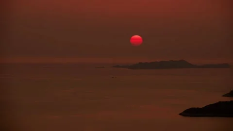Orange sky with sun going down into sea. Island in the sea Vídeo Stock 232227393