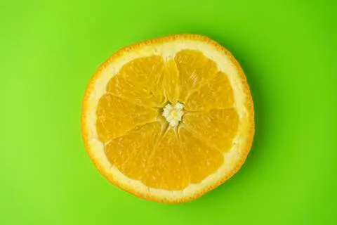 Orange slice close-up. isolate on a green background Stock Photos