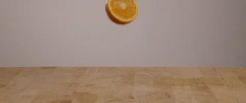 Orange Slice Falling Onto Cutting Board In Slow Motion 스톡 동영상 105376416