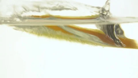 Orange slice falling water white background slow motion close up video Stock Footage 83932440