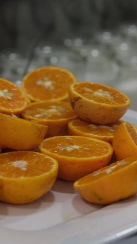 Orange slice falling on a white plate in slow motion. Ripe organic citrus fruits Stock Footage 310489399
