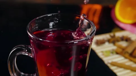 Orange slice falls into the top cup of mulled wine Stock Footage 295279293