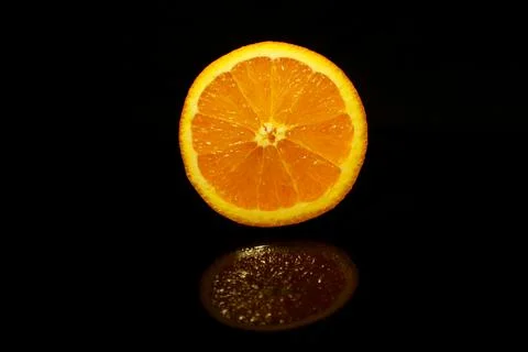 Orange slice isolated on black with reflection Stock Photos
