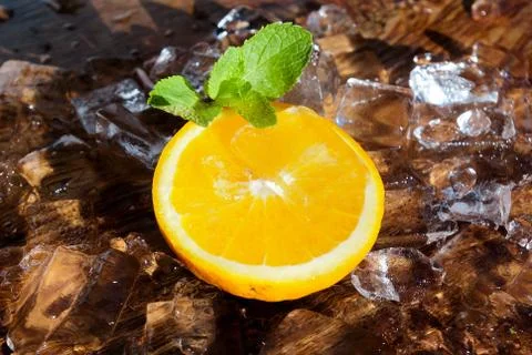 Orange slice with mint leaf on top of ice cubes Stock Photos