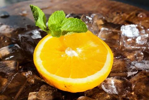 Orange slice with mint leaf on top of ice cubes Stock Photos