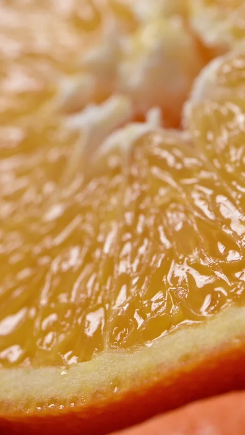 Orange slice revealed by moving light with warm dramatic mood Видео 332218806