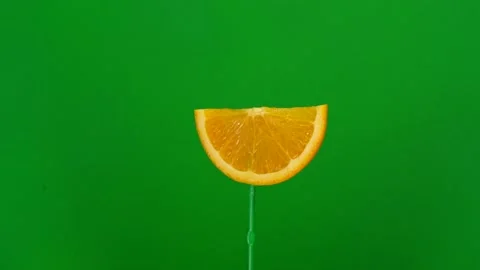 Orange slice spin on green screen Stock Footage 143549987