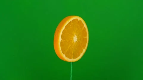 Orange slice spin on green screen Stock Footage