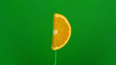 Orange slice spin on green screen Stock Footage 143550005