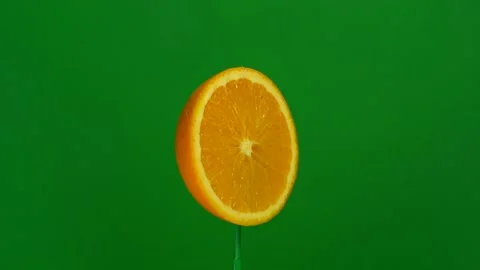 Orange slice spin on green screen Stock Footage 143557070