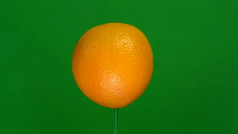 Orange slice spin on green screen Stock Footage 143557083