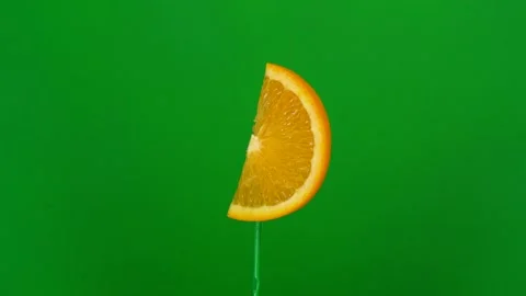Orange slice spin on green screen Stock Footage 143557227