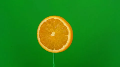 Orange slice spin on green screen Stock Footage 143557513