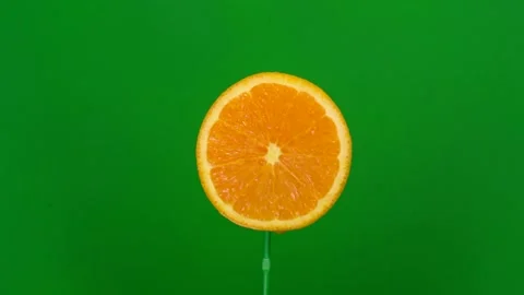 Orange slice spin on green screen Stock Footage 143557516