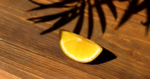 Orange slice on the table in the shade of a palm tree Stock Footage 246877329