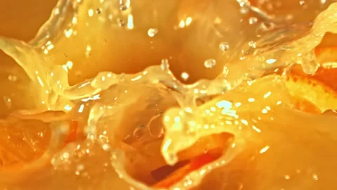 Orange slices fall into orange juice Stock Footage 229340113