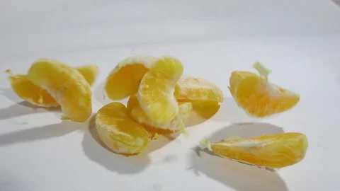 Orange slices fall on white background in slow motion Video stock 105646608