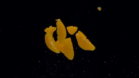 Orange slices falling in the air on black background Stock Footage 221484713