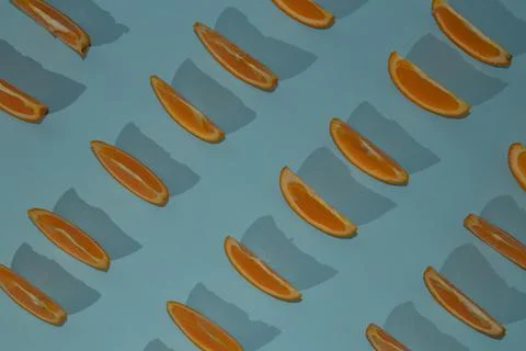 Orange slices, pattern, on a light blue background, with shadows. Stock Photos