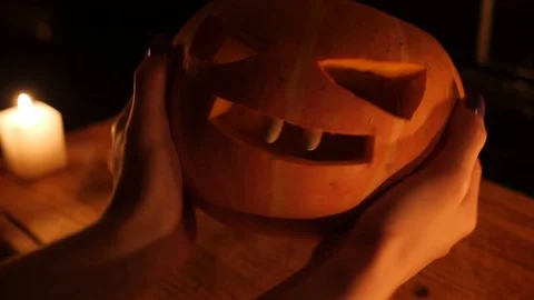 Orange small pumpkin on the cutting board in dark kitchen hand Stock Footage 97379943