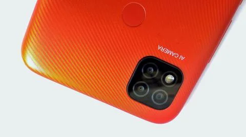 Orange smartphone with Artificial Intelligence (AI) cameras. Stock Photos