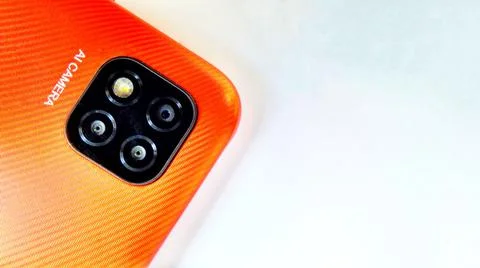 Orange smartphone with Artificial Intelligence (AI) cameras. Stock Photos