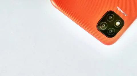 Orange smartphone with Artificial Intelligence (AI) cameras. Stock Photos
