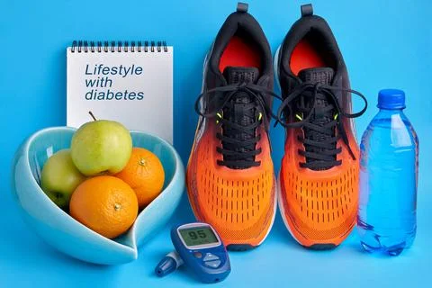 Orange sneakers, a notebook diary, a glucometer, a bottle of drinking water a Stock Photos
