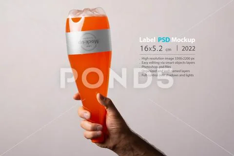 Orange soda plastic bottle at male hand isolated on gray background mock-up s PSD-sjabloon