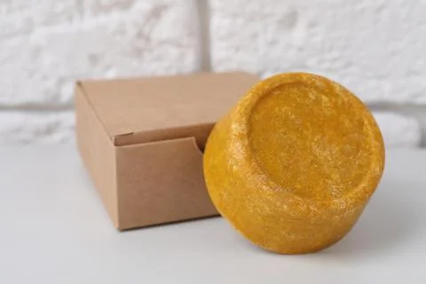 Orange solid shampoo bar and box on white table, closeup Stock Photos