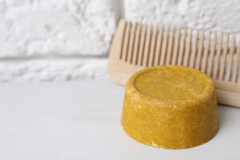 Orange solid shampoo bar and comb on white table, closeup. Space for text Stock Photos