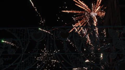Orange spark bursting through Fallas decorative metalwork at night in Valencia 스톡 사진