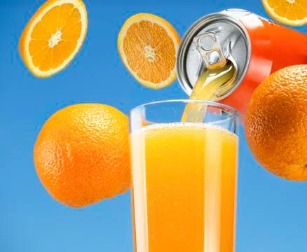 Orange sparkling water flows from a can into a glass. Stock Photos