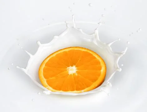 Orange splash in milk Stock Photos