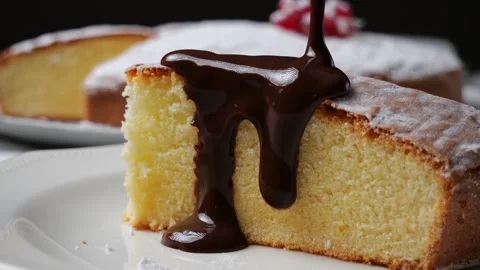Orange sponge cake pouring liquid chocolate. Close up. Slow motion Stock Footage 259396054
