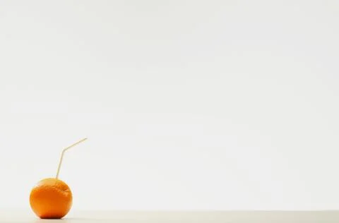 An Orange With A Straw Stock Photos
