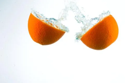 Orange in streams of water on a white background Stock Photos