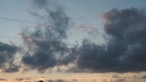 Orange summer sunset with dark gray rain clouds moving fast on warm evening Stock Footage 163185531