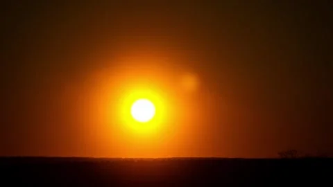 Orange Sun Setting Behind Horizon Silhouette In Clear Sky Time Lapse 스톡 동영상 330298496