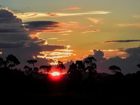 Orange sun setting in the mountains. Stock Photos